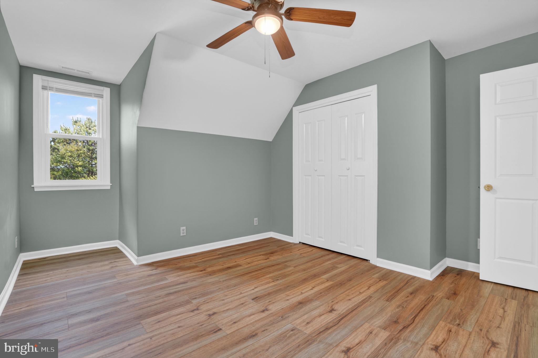 14123 Winterville Road Bloxom, VA 23308 - Photo 29 of 84 an empty room with wooden floor chandelier fan and windows