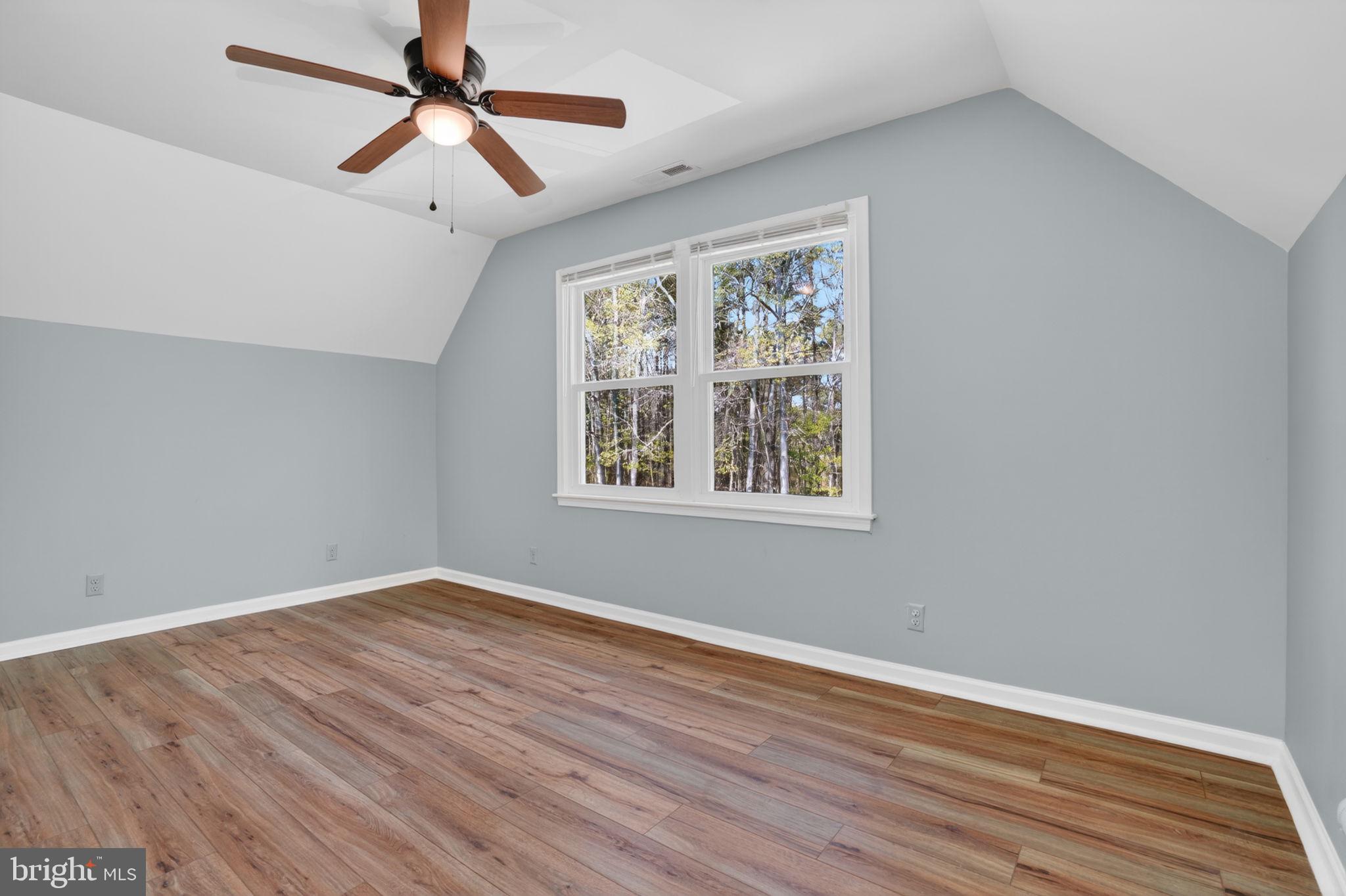 14123 Winterville Road Bloxom, VA 23308 - Photo 34 of 84 an empty room with wooden floor ceiling fan and windows