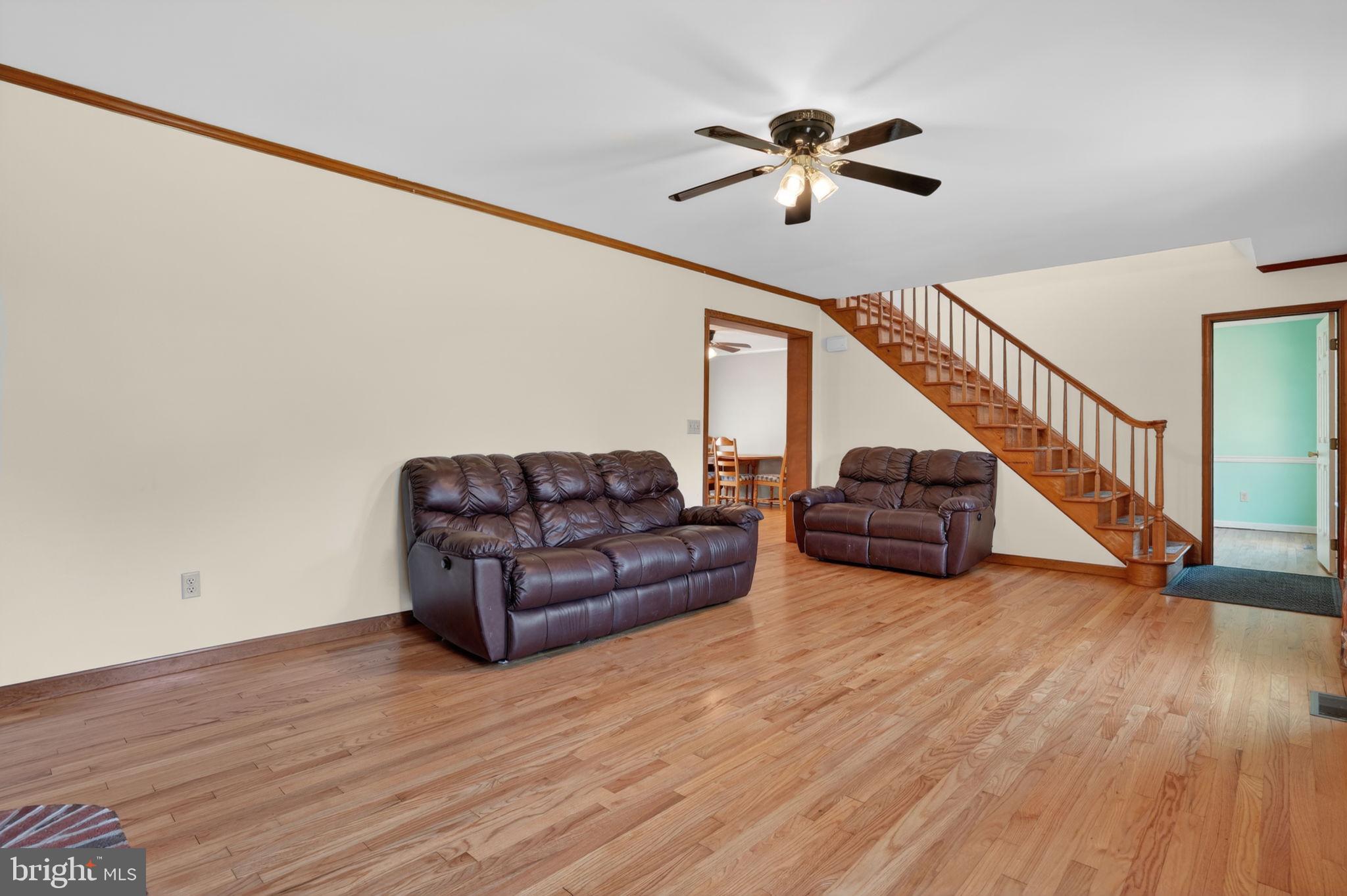 14123 Winterville Road Bloxom, VA 23308 - Photo 6 of 84 a living room with couches and stairs with wooden floor