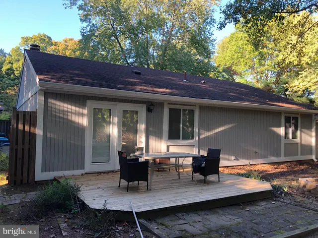 a view of house with backyard and outdoor seating