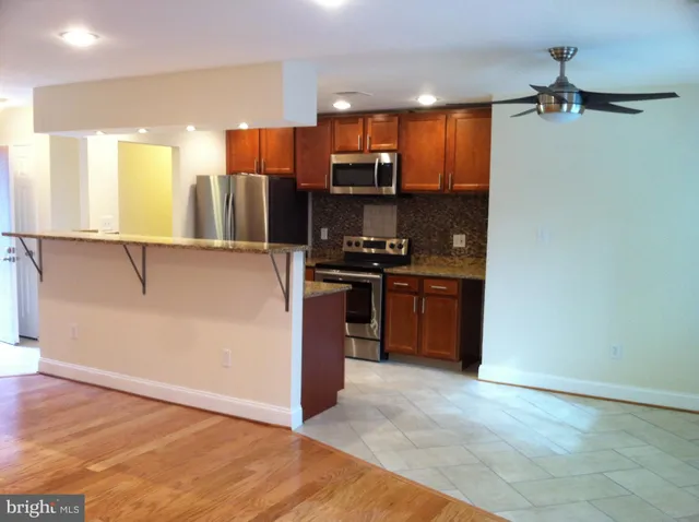 a kitchen with stainless steel appliances a refrigerator and a stove top oven