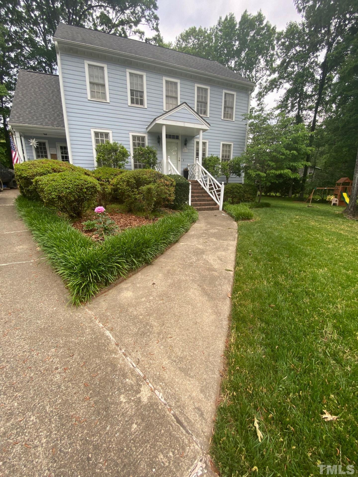 a front view of house with yard and green space