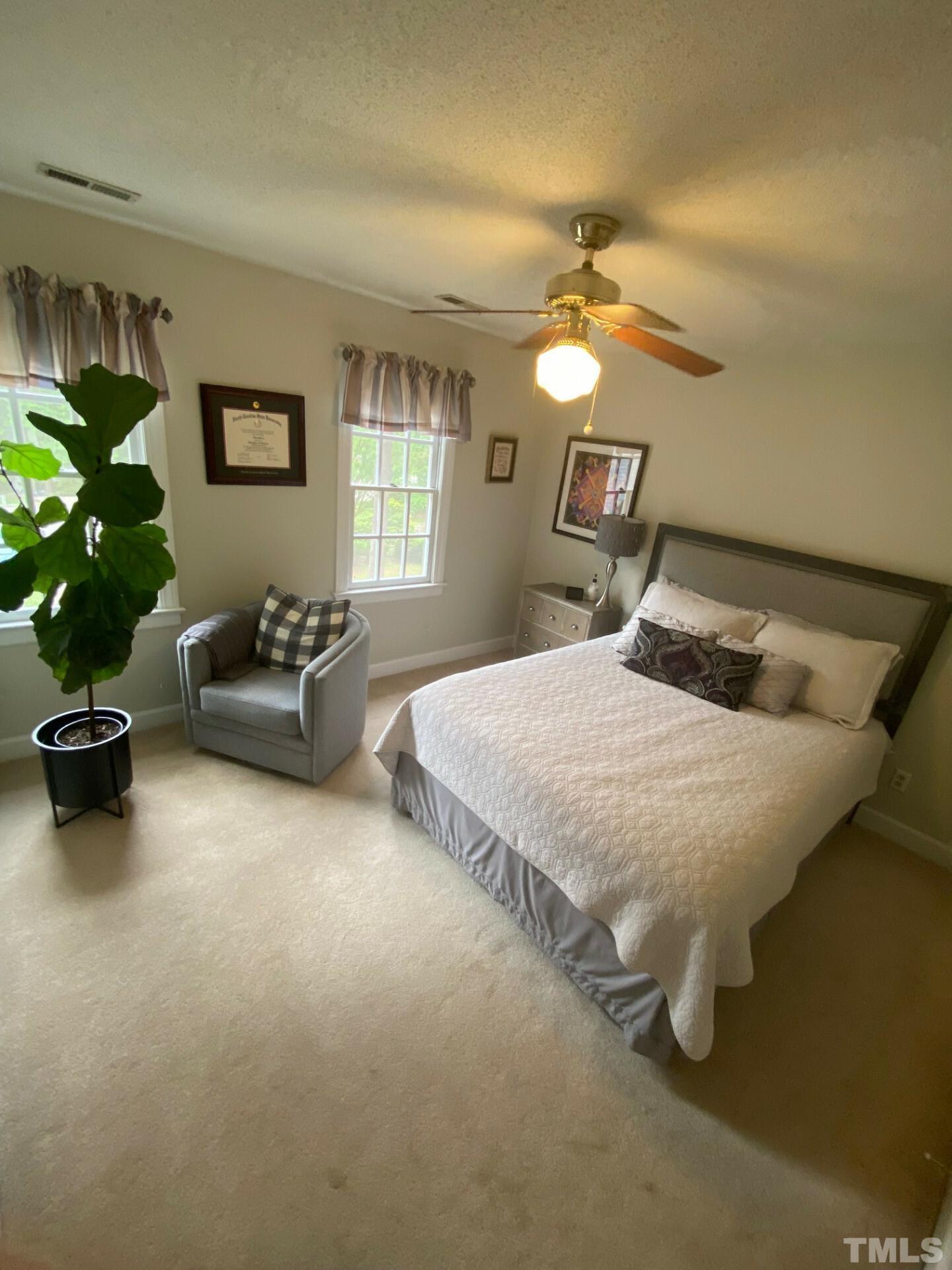 8713 Master Court Raleigh, NC 27615 - Photo 8 of 17 a bedroom with a bed and ceiling fan