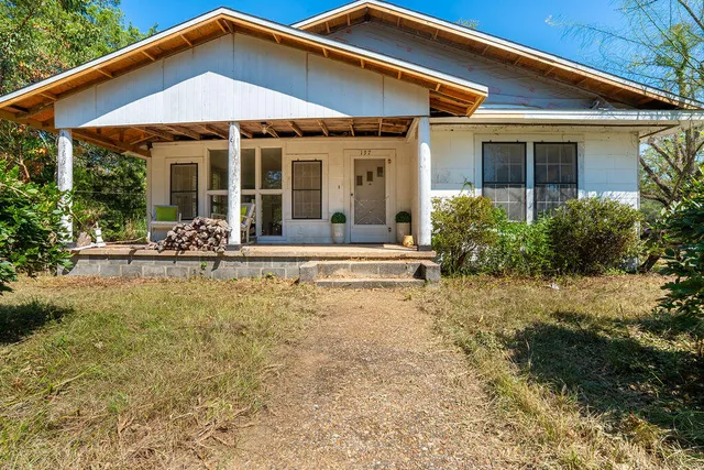 a porch with a table and chairs under an umbrella