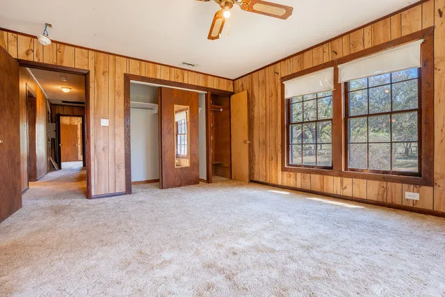 an empty room with windows and closet