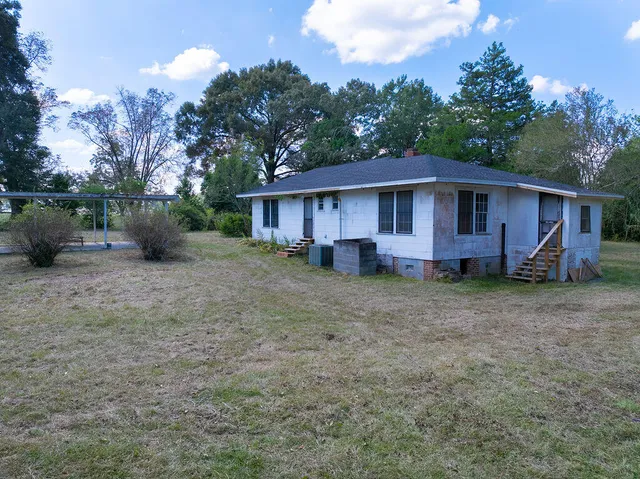 a view of a house with yard and sitting area