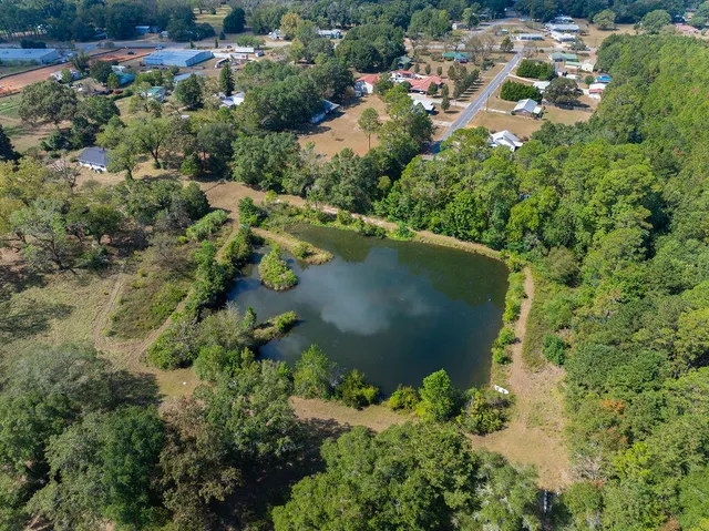an aerial view of a house with a yard and lake