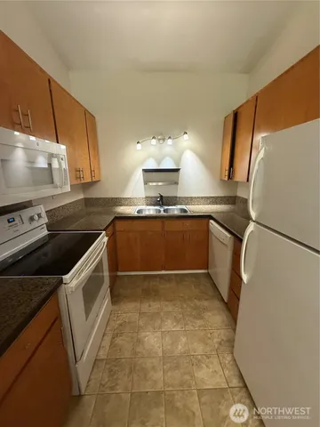 a kitchen with a sink a stove top oven and cabinetry