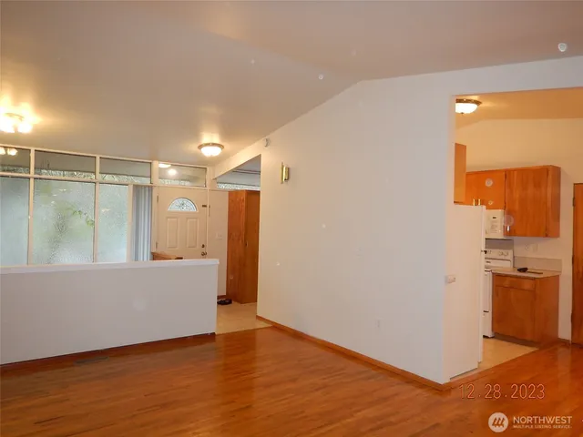 a view of a big room with wooden floor and windows