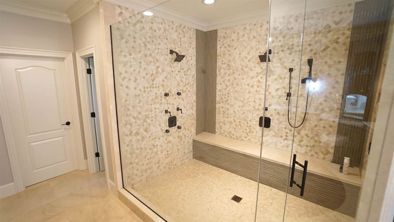 1608 Sharnbrook Court Raleigh, NC 27614 - Photo 17 of 30 Oversized, walk-in frameless shower for 2 w/tumbled tile flooring & matching tile surround, double shower heads, hand held sprayer, & built-in bench w/tile wall Master Bath/Spa