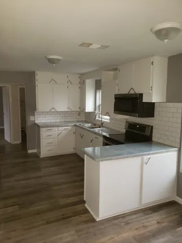 a kitchen with stainless steel appliances granite countertop a sink a stove top oven a counter space and cabinets