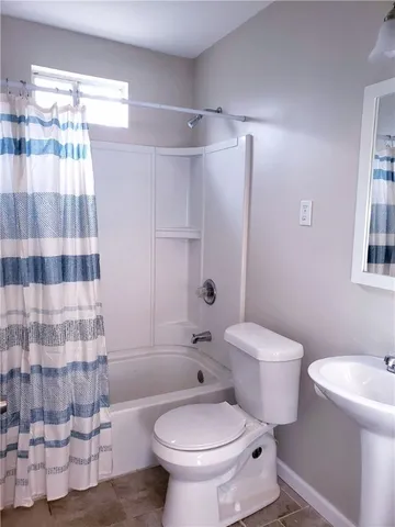 a white toilet sitting next to a bathroom sink and a shower