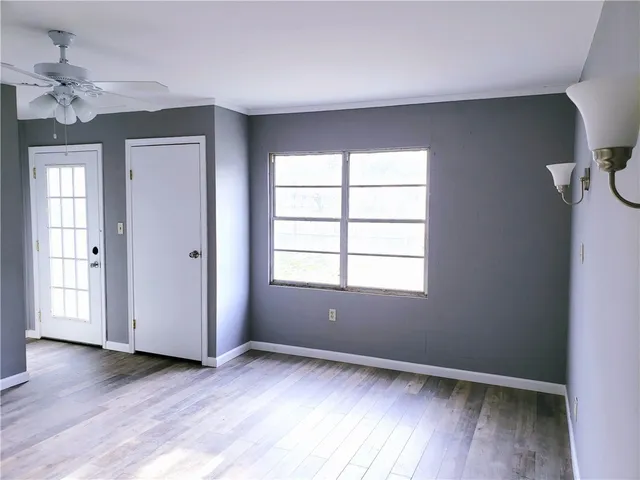 an empty room with wooden floor and windows