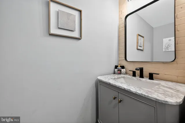a bathroom with a granite countertop sink vanity and mirror