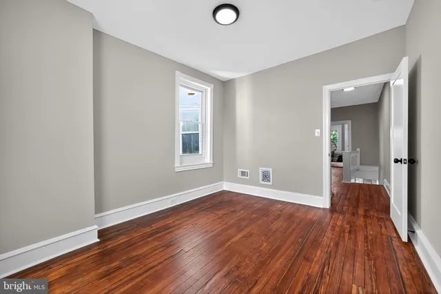 wooden floor in an empty room with a window