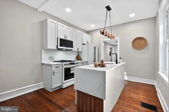 a kitchen with a stove and a wooden floor