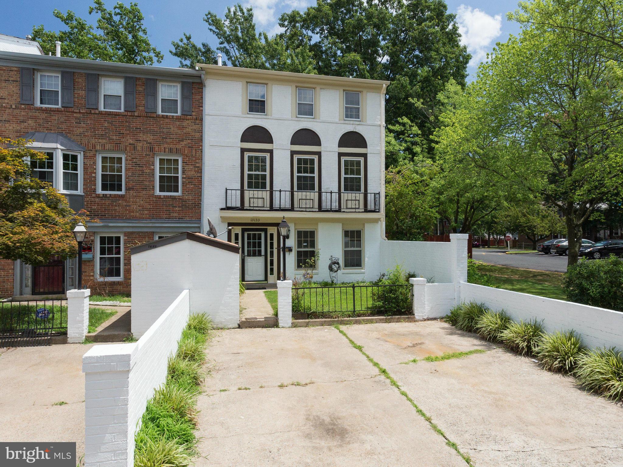 a front view of a house with a yard and potted plants