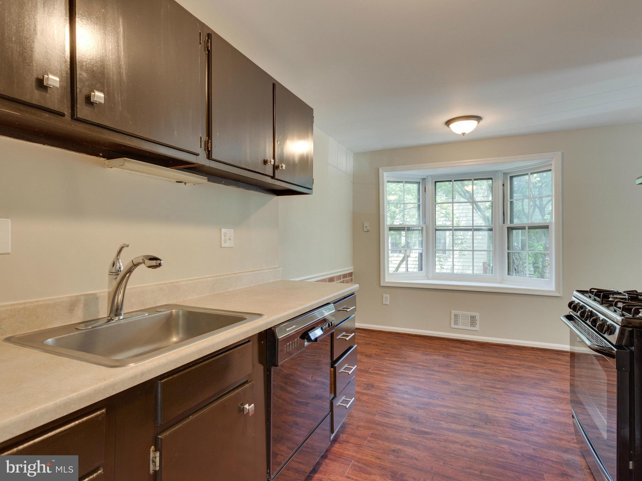 13133 Putnam Circle Woodbridge, VA 22191 - Photo 14 of 30 a kitchen with stainless steel appliances granite countertop a sink a stove and wooden floors