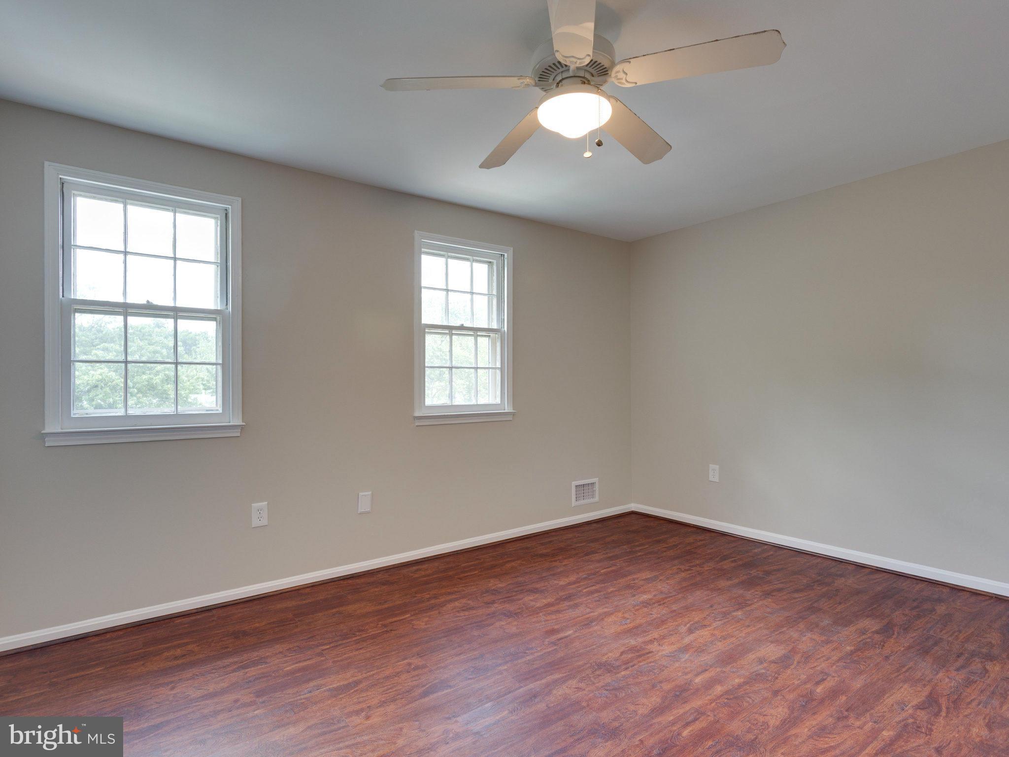 13133 Putnam Circle Woodbridge, VA 22191 - Photo 26 of 30 an empty room with wooden floor chandelier fan and windows