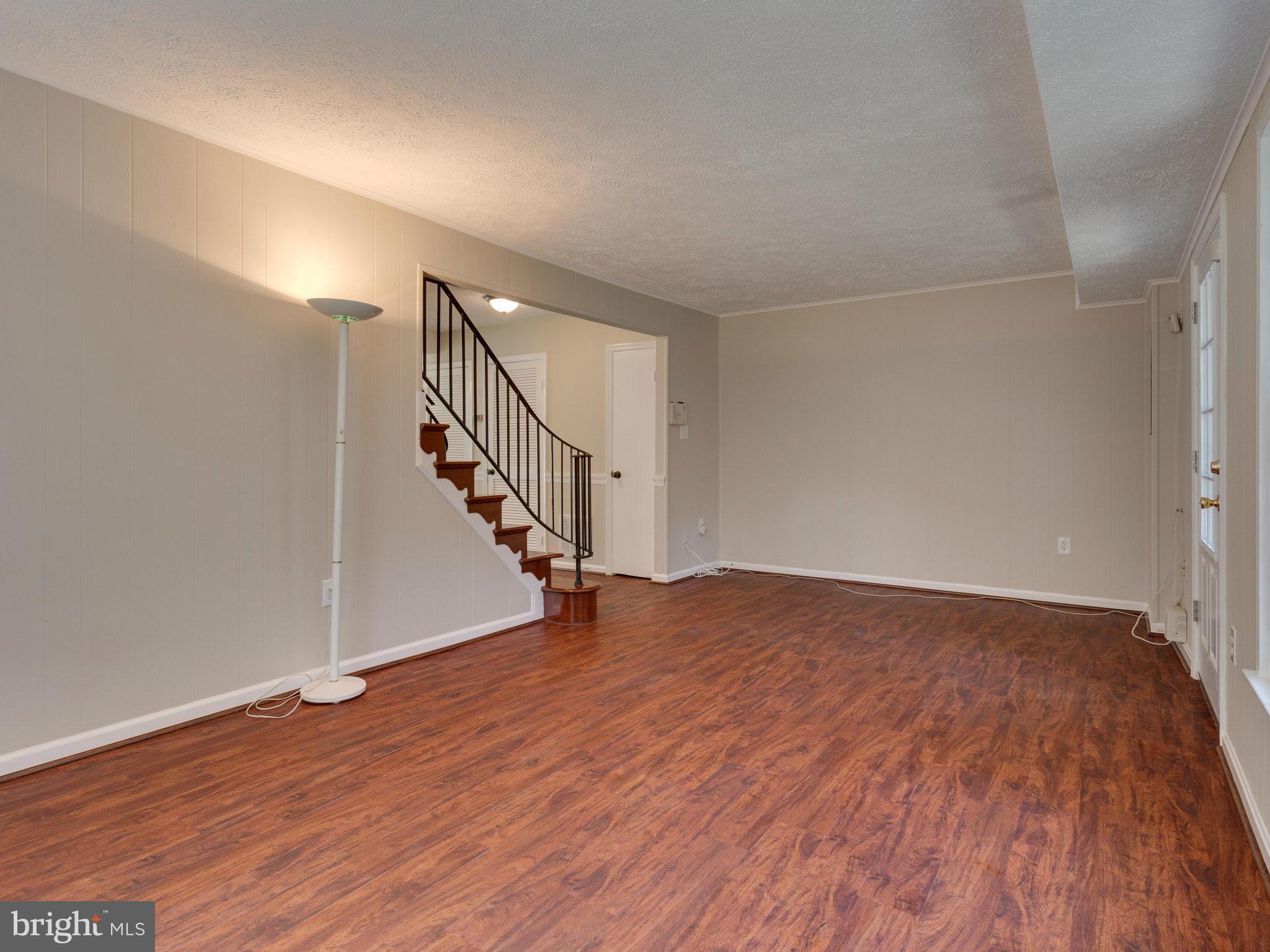 13133 Putnam Circle Woodbridge, VA 22191 - Photo 7 of 30 a view of an empty room with wooden floor and stairs