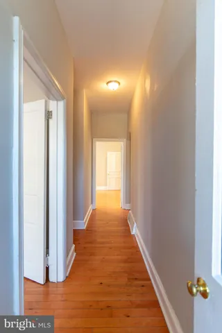 a view of a hallway with wooden floor