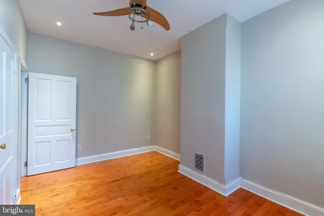 a view of empty room with wooden floor