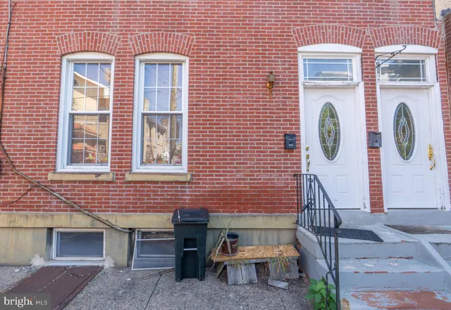 a view of a brick wall with a door and chair