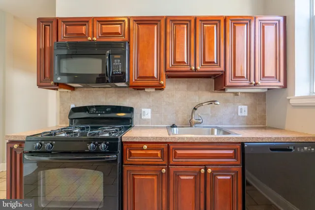 a kitchen with stainless steel appliances granite countertop a stove top oven microwave and cabinets
