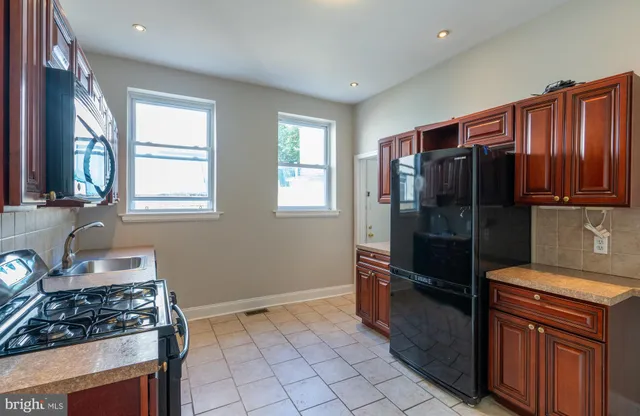 a kitchen with granite countertop a refrigerator stove and sink
