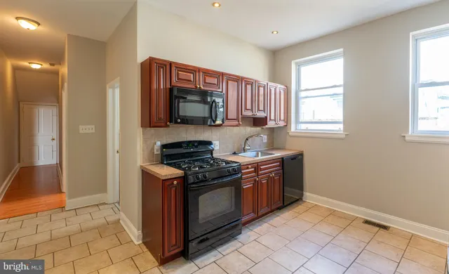 a kitchen with stainless steel appliances a stove a sink and a microwave