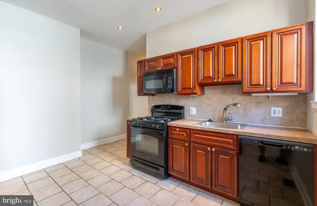 a kitchen with stainless steel appliances granite countertop a stove a sink and a microwave