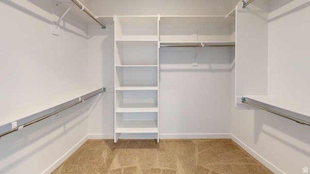 783 Pheasantbrook Drive, Unit 2A Centerville, UT 84014 - Photo 34 of 41 Walk-in closet featuring built-in shelving, multiple hanging rods, white walls, and carpet flooring