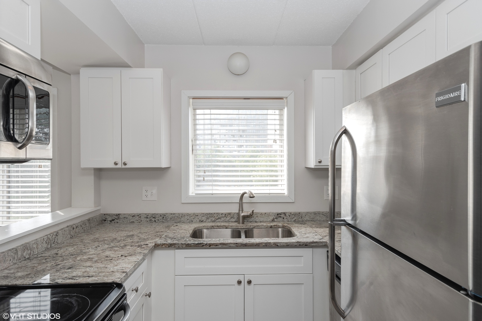 239 West 18th Street, Unit 2D Chicago, IL 60616 - Photo 2 of 10 a kitchen with granite countertop a sink cabinets and window