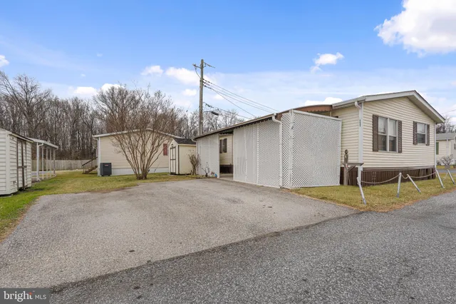 a view of a house with a backyard and road