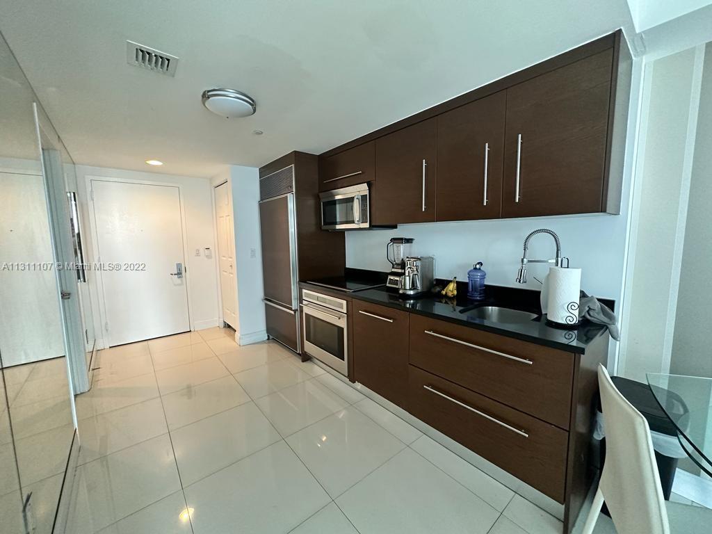 465 Brickell Avenue, Unit 3104 Miami, FL 33131 - Photo 14 of 21 a kitchen with stainless steel appliances granite countertop a refrigerator and a stove top oven