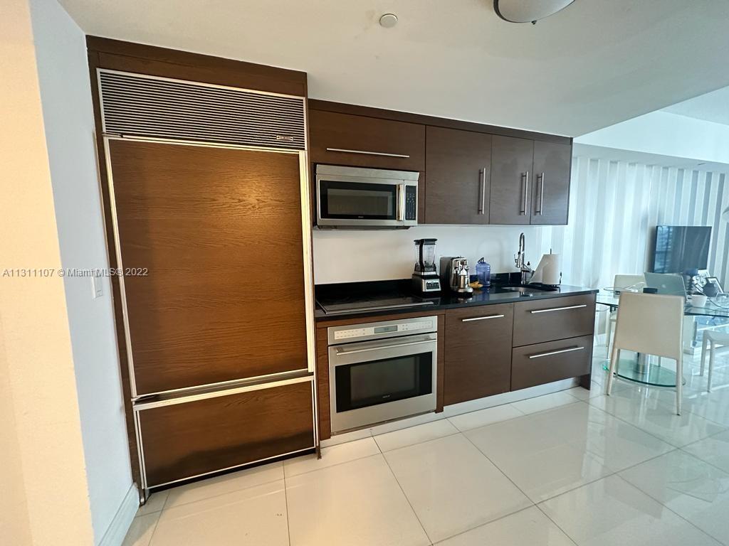 465 Brickell Avenue, Unit 3104 Miami, FL 33131 - Photo 15 of 21 a kitchen with a refrigerator and a stove top oven