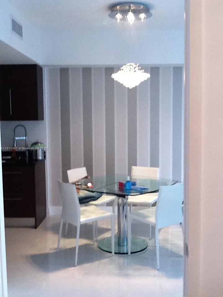 465 Brickell Avenue, Unit 3104 Miami, FL 33131 - Photo 7 of 21 a dining room with furniture and a flat screen tv
