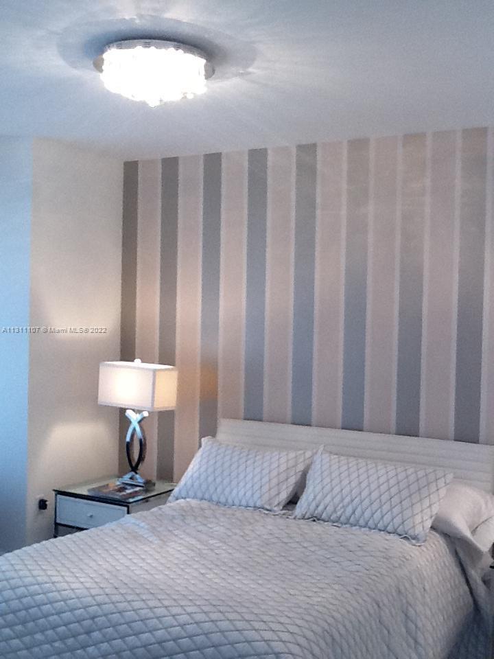 465 Brickell Avenue, Unit 3104 Miami, FL 33131 - Photo 8 of 21 a bedroom with a bed and a lamp