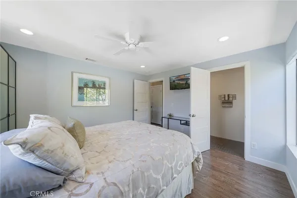a bedroom with a large bed and a chandelier