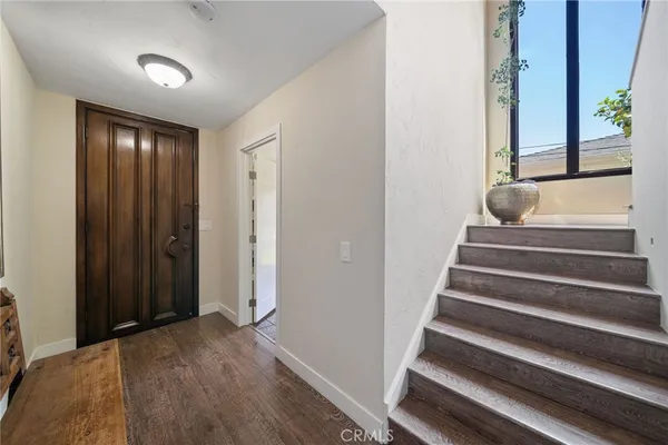 a view of a hallway with wooden floor and entryway