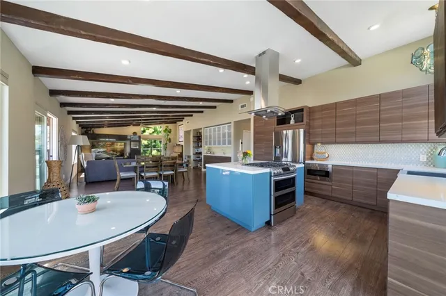 a kitchen with stainless steel appliances kitchen island granite countertop a sink a counter space and chairs