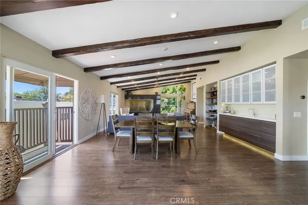 a dining room with wooden floor a glass table and chairs