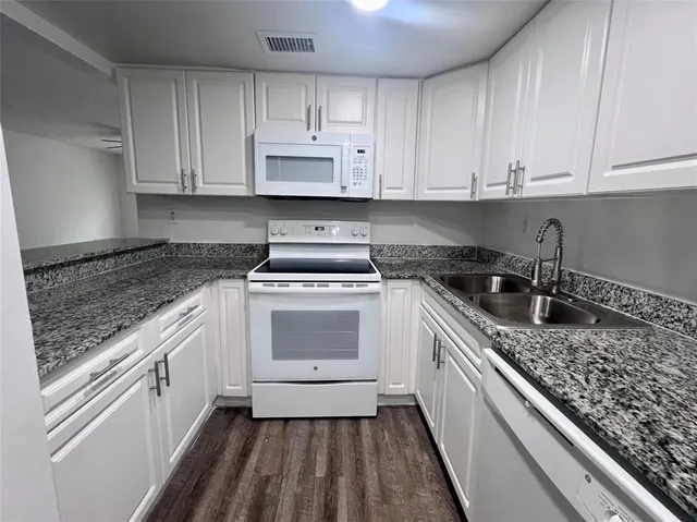 a kitchen with a sink stove and cabinets
