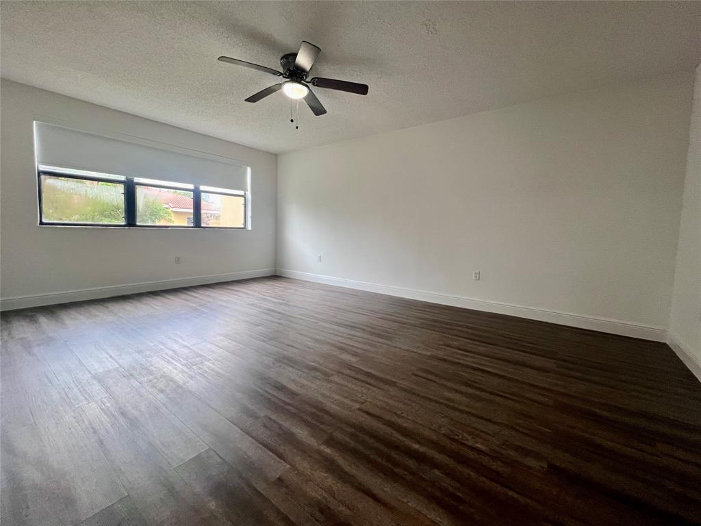 17350 Northwest 68th Avenue, Unit 400416 Hialeah, FL 33015 - Photo 4 of 16 an empty room with wooden floor and windows