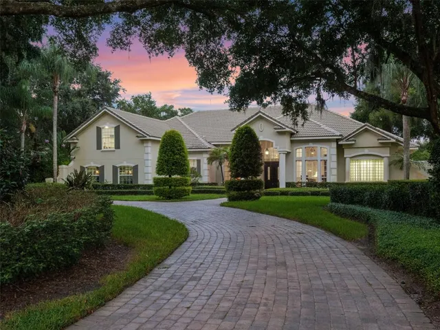 a front view of a house with a garden and yard