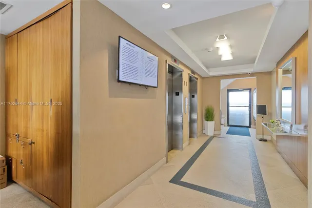 a view of a hallway with wooden floor and cabinet