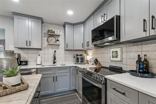 a kitchen with stainless steel appliances granite countertop a sink a stove a microwave and cabinets