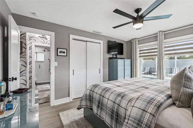 a bedroom with a large bed a flat tv screen and a window