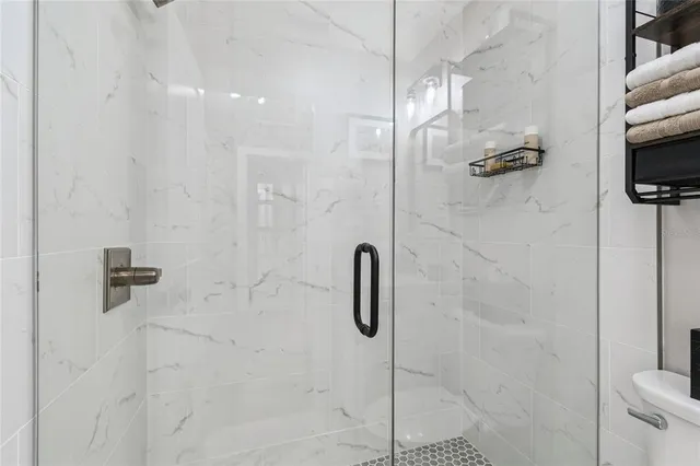 a bedroom with a large bed and a flat tv screen on dresser