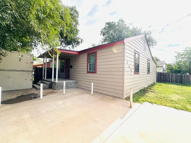 a backyard of a house with barbeque oven table and chairs